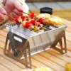 Outdoor Camping BBQ Grill Edelstahl Klappbarbecue Grill Holzofen Campingkocher Holzkohlegrill Camping BBQ Ausrüstung